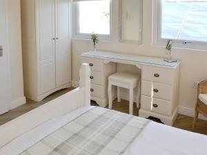 a white bedroom with a desk and a bed at High Trees Annex in Widdrington