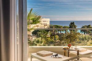 a room with a balcony with a view of the ocean at Anantara Plaza Nice Hotel - A Leading Hotel of the World in Nice
