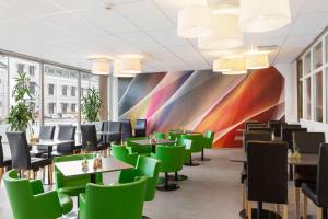 a dining room with tables and chairs and a colorful wall at Sure Hotel by Best Western City Jonkoping in Jönköping