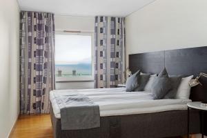 een slaapkamer met een groot bed en een groot raam bij Sure Hotel by Best Western City Jonkoping in Jönköping