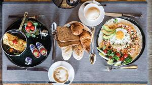 a table with plates of breakfast foods and a cup of coffee at Luxury Suites Amsterdam in Amsterdam