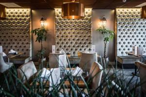 Luxury Suites Amsterdam في أمستردام: مطعم بطاولات وكراسي وجدار كبير