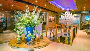 Luxury Suites Amsterdam في أمستردام: غرفة بها إناء من الزهور على طاولة