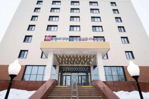a large white building with a staircase in front of it at Best Western Plus Oskemen in Ustʼ-Kamenogorsk