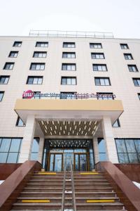 a large white building with stairs leading up to it at Best Western Plus Oskemen in Ustʼ-Kamenogorsk