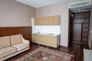 a living room with a couch and a kitchen at Best Western Plus Oskemen in Ustʼ-Kamenogorsk