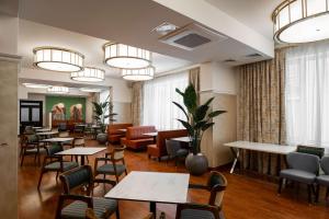 une salle d'attente avec des tables et des chaises et un coin d'attente dans l'établissement Best Western Plus Oskemen, à Öskemen