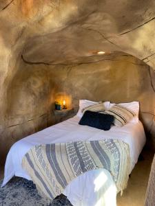 Bett in einem Zimmer in einer Höhle in der Unterkunft Zion Glamping Adventures in Hildale