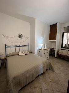 a bedroom with a bed and a dresser in it at La Casa di Spinosella in Valledoria