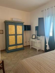 a bedroom with a bed and a cabinet and a table at La Casa di Spinosella in Valledoria