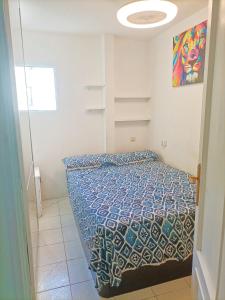 a bedroom with a bed with a blue comforter at HABITACION EN CHUECA, CENTRO DE MADRID in Madrid