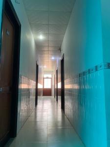 un couloir avec des murs bleus et une porte dans l'établissement NHÀ NGHỈ NAM PHƯƠNG, à Hà Tiên