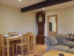 sala de estar con mesa y reloj de abuelo en Rosemount Cottage, en Salterforth