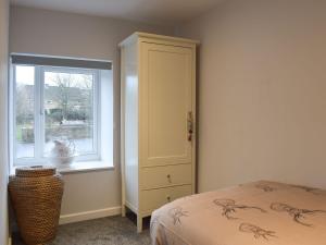 a bedroom with a bed and a window at Rosemount Cottage in Salterforth