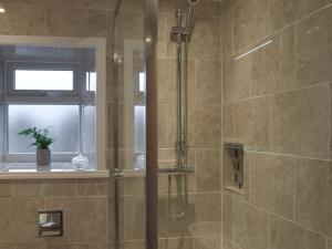 a shower with a glass door in a bathroom at Rosemount Cottage in Salterforth