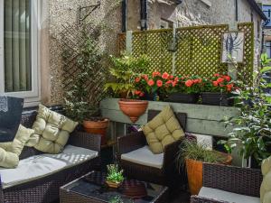 um pátio com cadeiras de vime e vasos de plantas em The Haven em Heysham