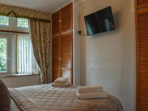 um quarto com uma cama e uma televisão na parede em The Haven em Heysham