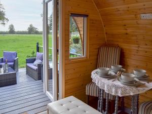a room with a table and chairs on a porch at Park View - Ukc4925 in Roydon
