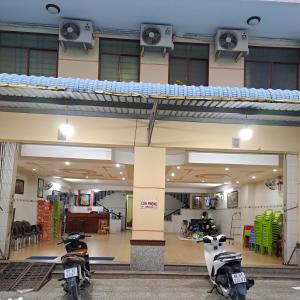dos motocicletas estacionadas en un edificio con un loft en NHÀ NGHỈ NAM PHƯƠNG en Ha Tien