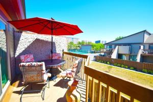a patio with a table and a red umbrella at Club Ocean Villas II 19 condo in Ocean City