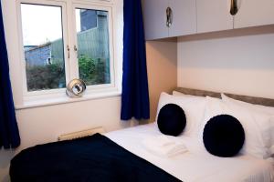 a bedroom with a bed with two pillows and a window at Modern 3 Bed House in Wolverhampton