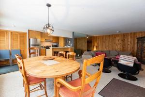 a kitchen and dining room with a wooden table and chairs at Northwoods Ski In Ski Out Access in Vail