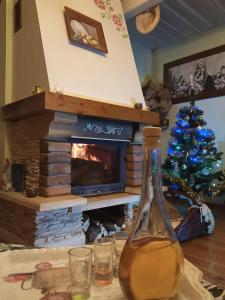 a christmas tree in a living room with a fireplace at Leśniczówka domek sauna jeziorko w lesie na wyłączność in Straszydle