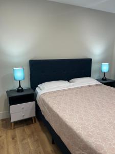 a bedroom with a bed and two lamps on tables at City Modern Apartment in Charlottetown