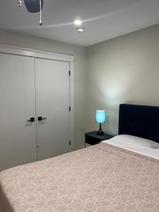 a bedroom with a bed and a closet and a blue lamp at City Modern Apartment in Charlottetown