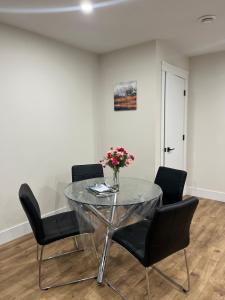 a dining room with a glass table and chairs at City Modern Apartment in Charlottetown