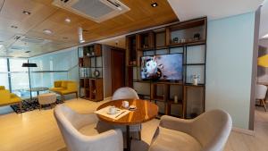 a living room with a table and chairs and a television at Hotel Treinta-Seis in Mar del Plata