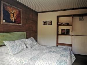 Un dormitorio con una cama y un frigorífico. en Cabaña Canto del Zorzal, en Villarrica