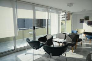 a room with chairs and tables and large windows at Montañeses 2830 Duplex Flat in Buenos Aires