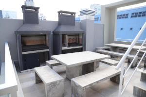 a patio with a table and benches and a fireplace at Montañeses 2830 Duplex Flat in Buenos Aires