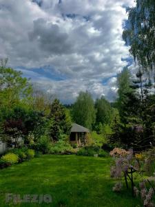 einen Garten mit einem Haus in der Mitte eines Gartens in der Unterkunft Filezja 