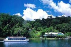 a boat in the water next to a house at A picturesque 3 bedroom house with splendid views in Atherton