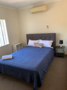 1 dormitorio con 1 cama grande con manta azul en A picturesque 3 bedroom house with splendid views, en Atherton