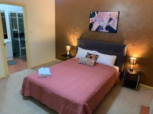 a bedroom with a large bed with a pink blanket at A picturesque 3 bedroom house with splendid views in Atherton