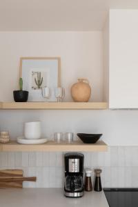 a kitchen counter with a coffee maker on a shelf at The Laurel Loft in San Diego