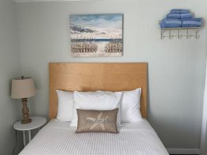a bedroom with a bed with a pillow on it at Moontide Motel, Apartments, and Cabins in Old Orchard Beach