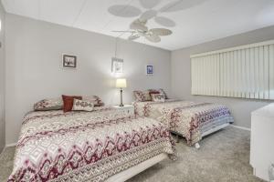 a bedroom with two beds and a ceiling fan at Oceana II 109 condo in Ocean City
