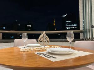 una mesa con platos y copas de vino en el balcón en Rentaqui - Apartament Paulista Wall Street Diamond, en São Paulo