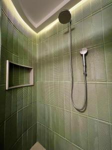 baño de azulejos verdes con ducha. en Rentaqui - Apartament Paulista Wall Street Diamond, en São Paulo
