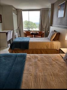 a hotel room with two beds and a window at Antonio's Hotel e Spa - Airport in Brasilia