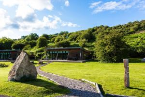 a building in a field with a large rock at Yorkshire Dales Lodge 3 Family 3 Bed in Richmond