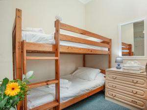 a bedroom with two bunk beds and a dresser with a mirror at Apartment Two - Uk39835 in Paignton