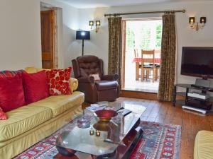 - un salon avec un canapé et une table dans l'établissement Pigeon Coo Farmhouse, à Shalfleet