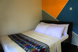 a bedroom with a bed with a colorful wall at Laluna Narmada in Narmada