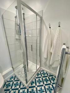 a bathroom with a glass shower stall and towels at The Snug at Caphays: perfect rural retreat in Long Burton