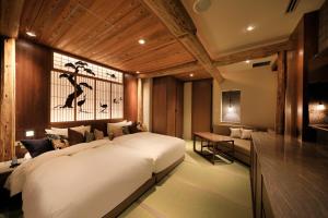 een slaapkamer met een groot wit bed en een bureau bij Hotel Gion Ichirin in Kyoto